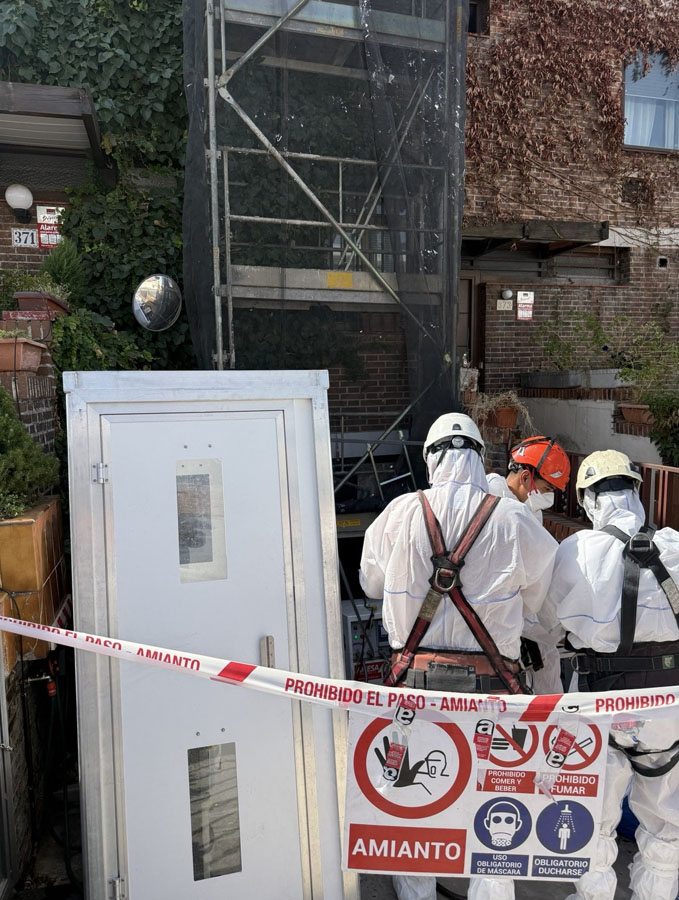 unidad de descontaminación instalada jusnto a la zona de trabajo señalizada por riesgo de amianto