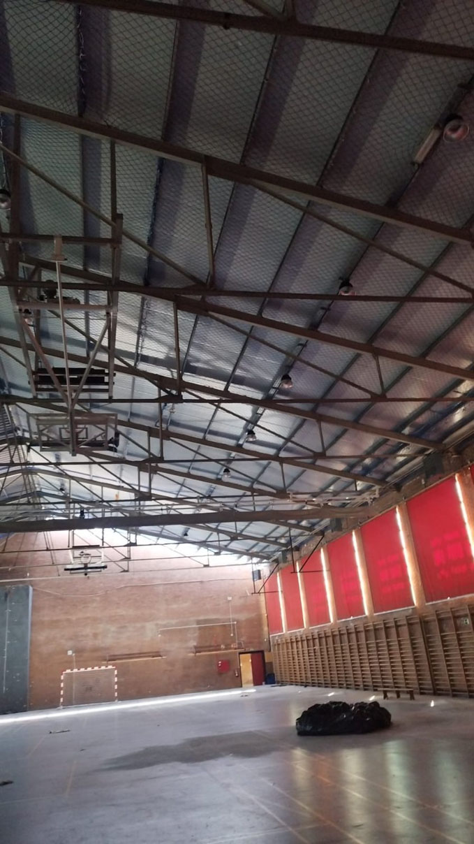 Vista interior de una cubierta de fibrocemento con estructura metálica y falso techo