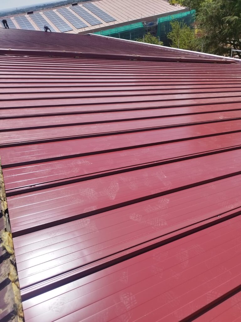Cubierta nueva de panel sándwich rojo instalada en el IES San Fernando tras retirar el amianto